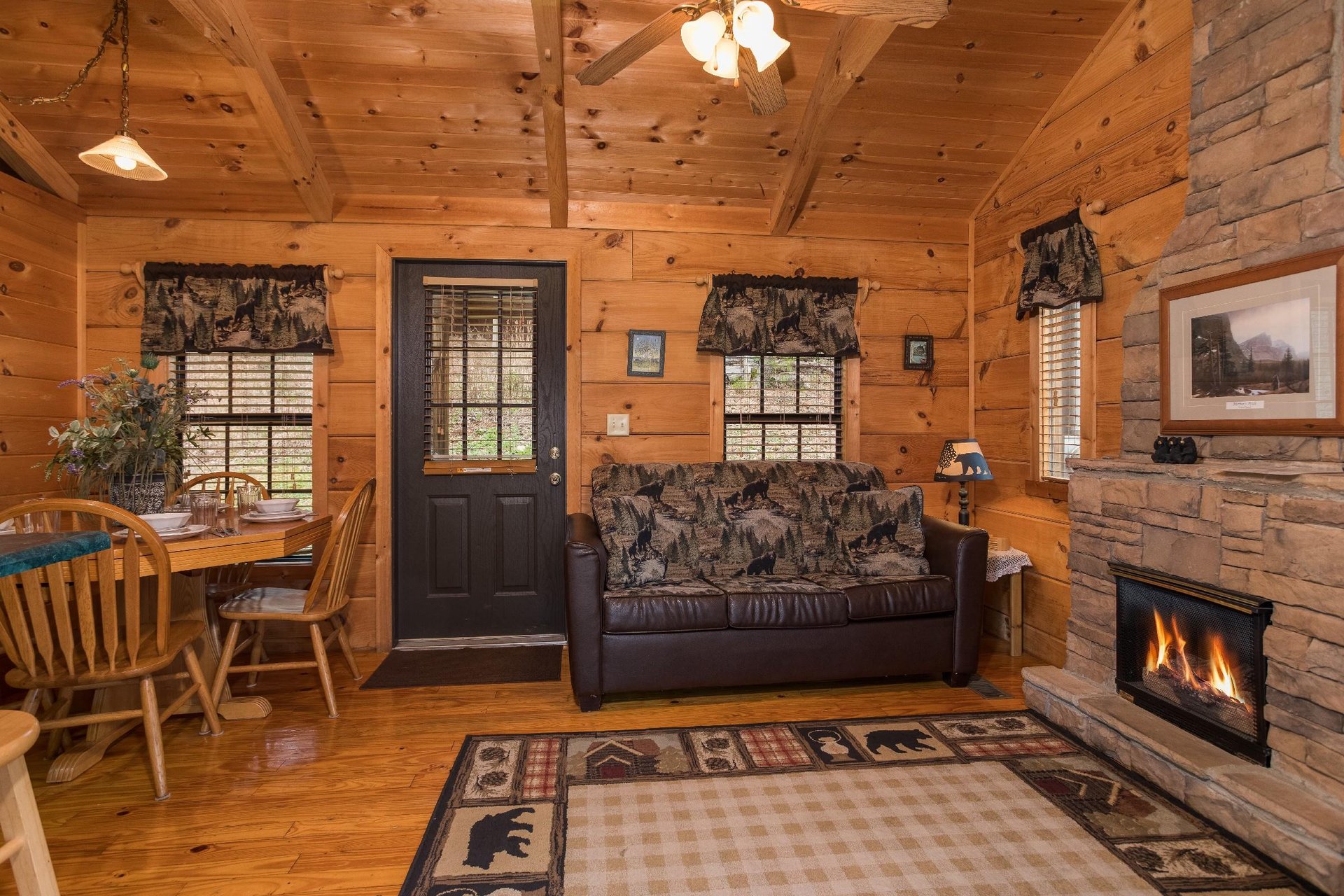 Sofa, fireplace, and dining table in the living space at Boogie Bear, a 1bedroom cabin rental located in Gatlinburg
