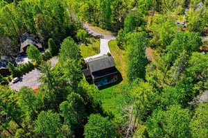 Secluded retreat nestled among towering trees and winding roads in a peaceful forested neighborhood.