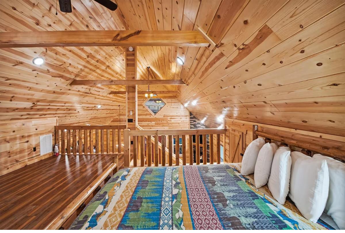 Cozy up in your private loft bedroom with rustic wood beams and colorful quilted bedding for mountain cabin charm.