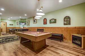 Challenge friends to pool in your private game room, complete with cozy fireplace and stylish seating for ultimate relaxation.