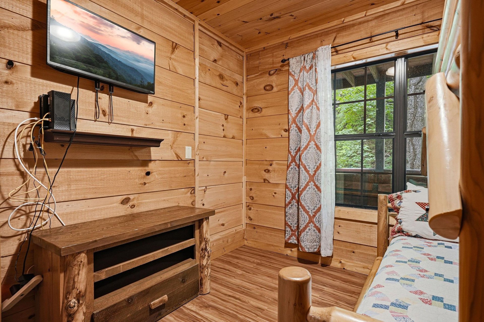 Unwind in your cozy cabinstyle retreat with warm woodpaneled walls, comfy seating by the window, and a TV for relaxing mountain evenings. The perfect hideaway to recharge after your adventures.