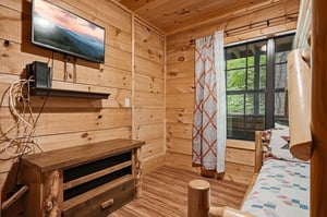 Unwind in your cozy cabinstyle retreat with warm woodpaneled walls, comfy seating by the window, and a TV for relaxing mountain evenings. The perfect hideaway to recharge after your adventures.
