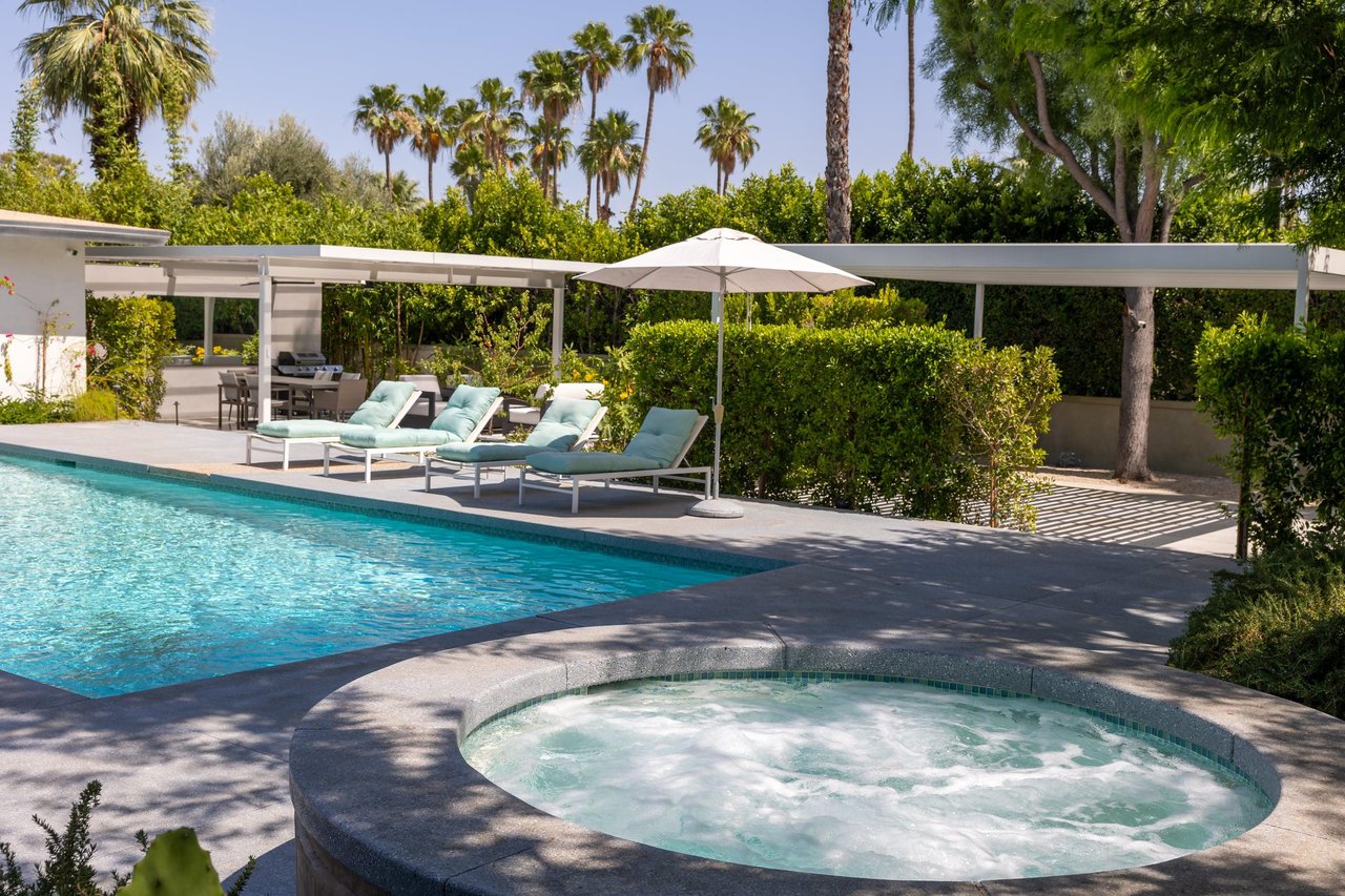 Private poolspa with sun loungers and umbrellas.