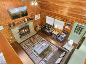 Cozy up in this rustic living room where warm wood surrounds you and the stone fireplace creates the perfect ambiance for relaxation.