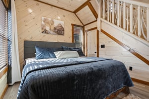 Cozy under exposed wooden beams, your comfortable bedroom features rustic charm with modern touches for restful nights.