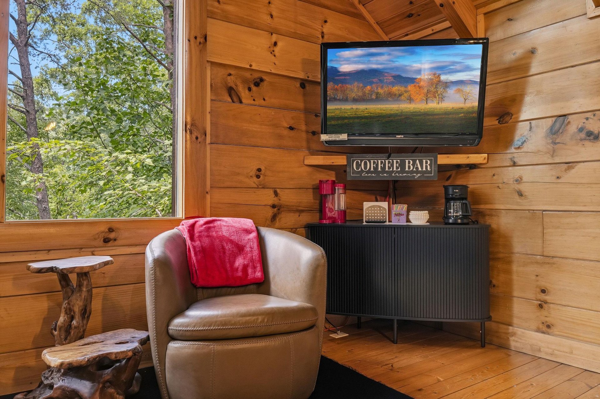 Settle into the cozy leather chair with your morning coffee from the convenient inroom coffee bar, surrounded by warm wood and natural light streaming through the window.