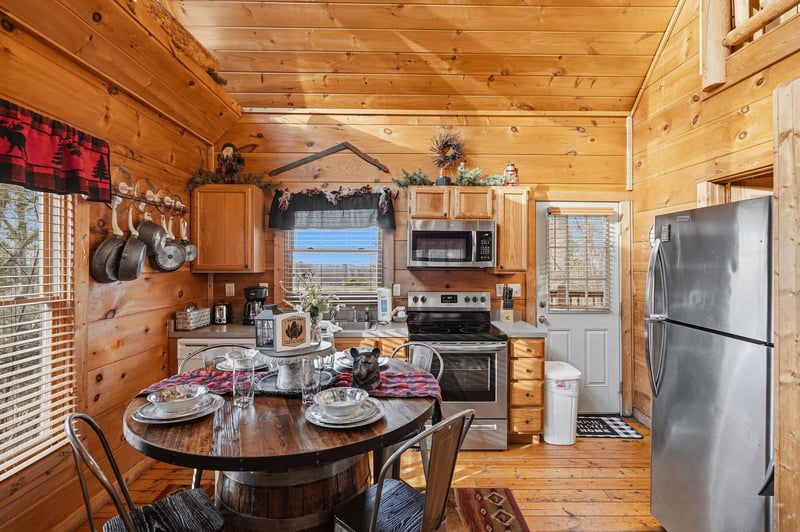 Your cozy cabin kitchen features rustic wood charm with modern appliances, perfect for preparing hearty meals together.