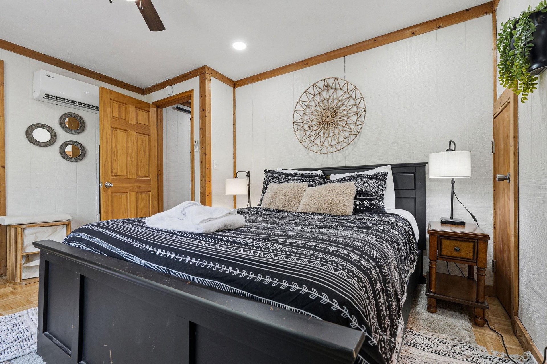 Relax in your cozy bedroom with rustic wood beams, stylish tribalpattern bedding, and thoughtful touches like hanging greenery and warm lighting.