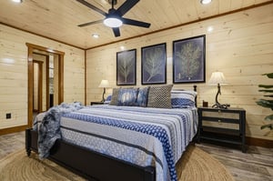 Drift off in your serene bedroom with warm woodpaneled walls, elegant botanical art, and a plush bed designed for restful nights.