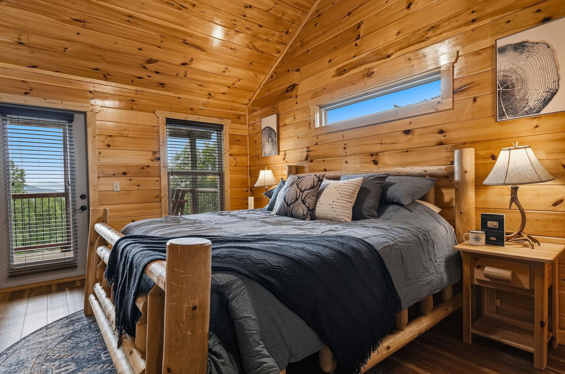 Sink into the plush log bed and wake to natural light streaming through vaulted pine ceilings, with your private balcony just steps away.