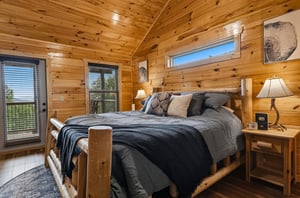 Sink into the plush log bed and wake to natural light streaming through vaulted pine ceilings, with your private balcony just steps away.