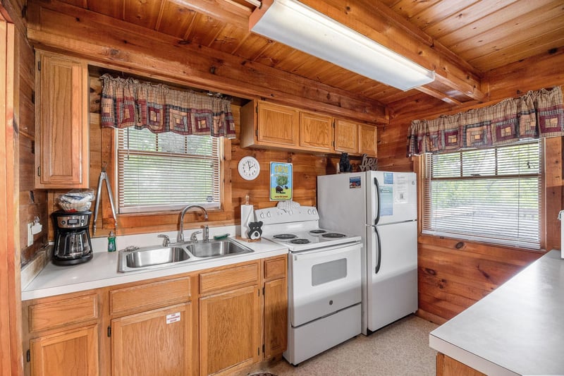 Kitchen with white appliances at Beary Good Time, a 1bedroom cabin rental located in Pigeon Forge