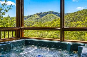 Soak in your private hot tub as you gaze out at rolling mountains and endless green treetops—pure relaxation with natures beauty framing every moment.