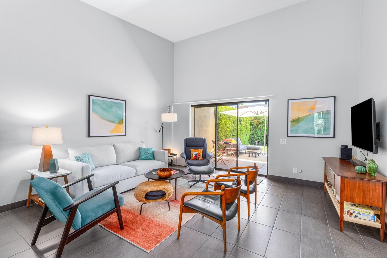 Living room has direct patio access, smart TV, ample seating, and openconcept living space.