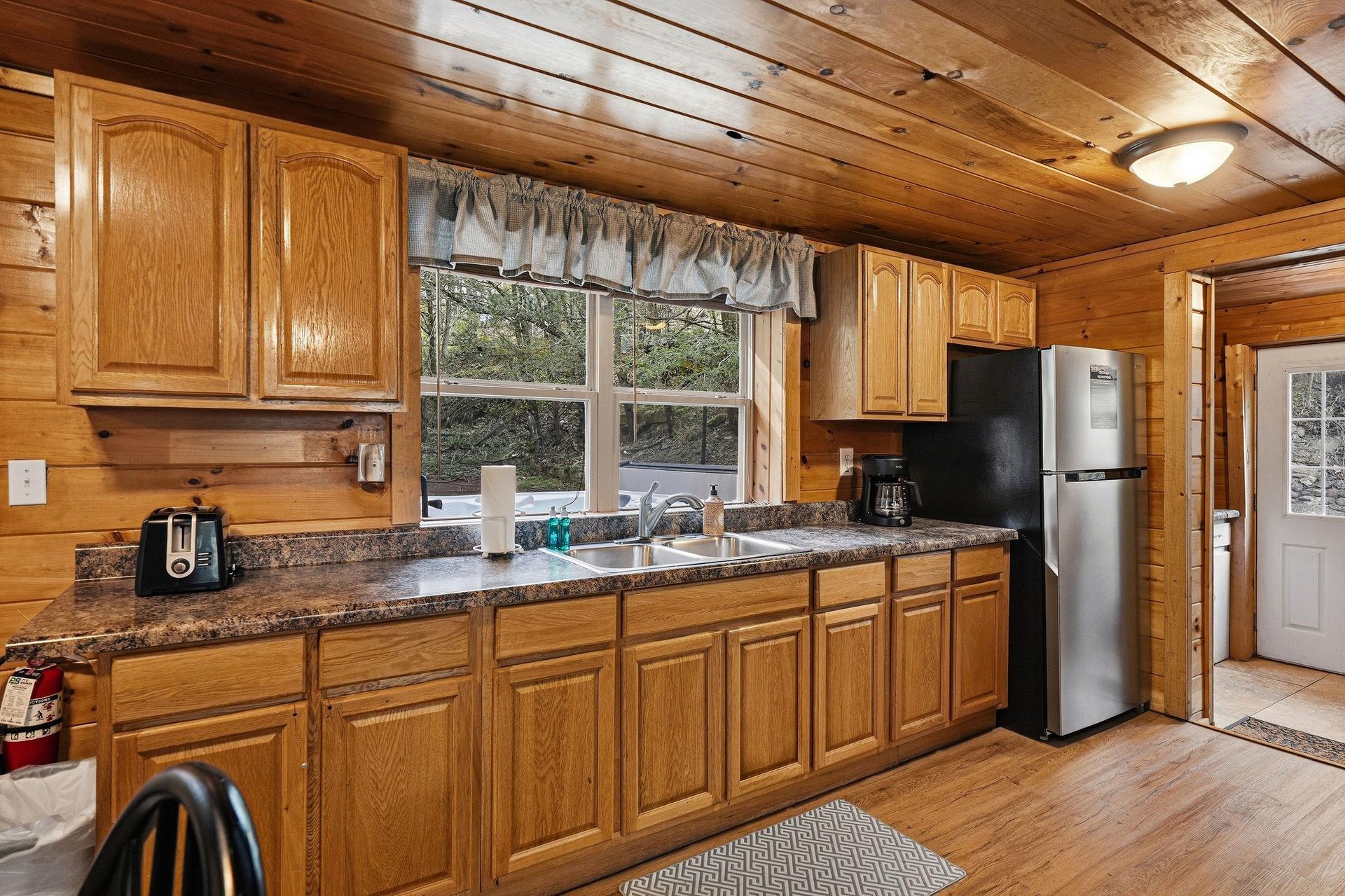 Your fullyequipped kitchen features granite countertops, oak cabinets, and modern appliances with natural light streaming through the window.