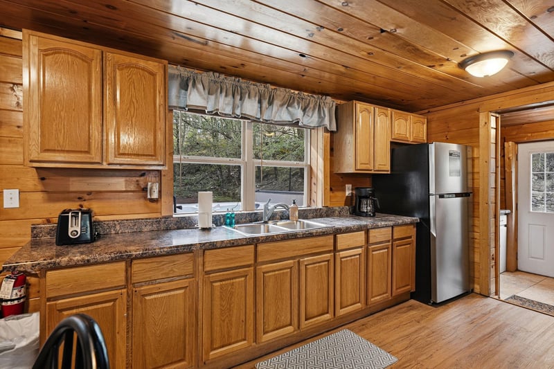 Your fullyequipped kitchen features granite countertops, oak cabinets, and modern appliances with natural light streaming through the window.