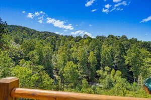 Breathe in the fresh mountain air from your private deck, surrounded by endless wooded hills and clear blue skies.