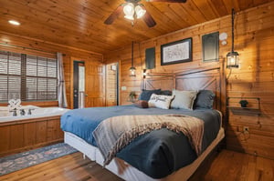 Your rustic suite blends warmth with luxury—rich wood walls, cozy bedding, and a romantic jetted tub for two.