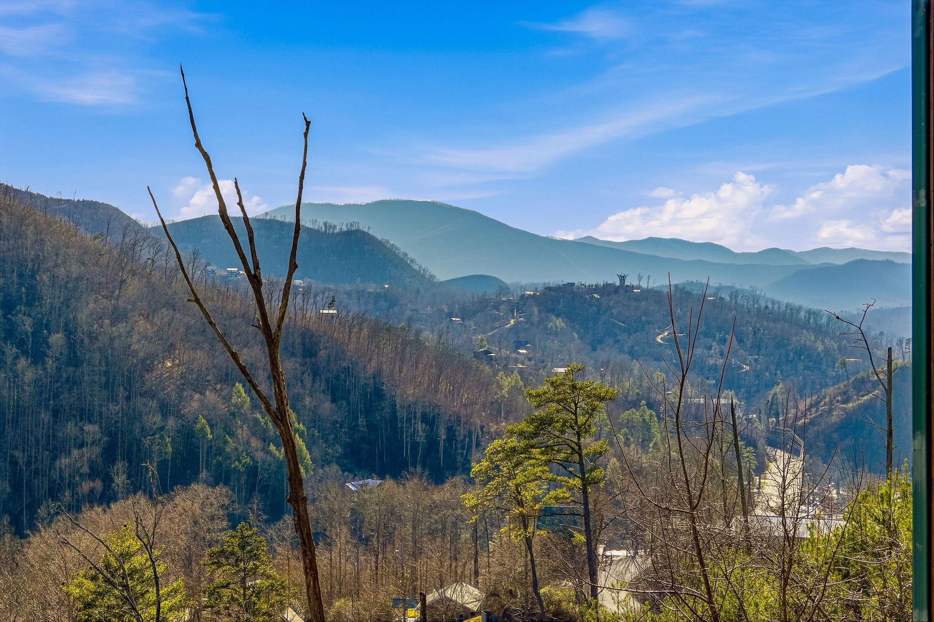 Sweeping mountain vistas stretch endlessly beyond rolling hills dotted with homes, creating a peaceful backdrop for the propertys location.