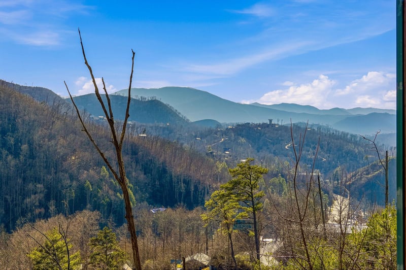 Sweeping mountain vistas stretch endlessly beyond rolling hills dotted with homes, creating a peaceful backdrop for the propertys location.