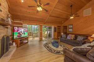 Living room with TV, fireplace, and deck access at Cubs Crib, a 3 bedroom cabin rental located in Gatlinburg