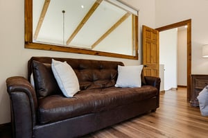 Sink into the leather sofa and enjoy the vaulted ceilings and warm wood beams that give this space its cozy, rustic charm.