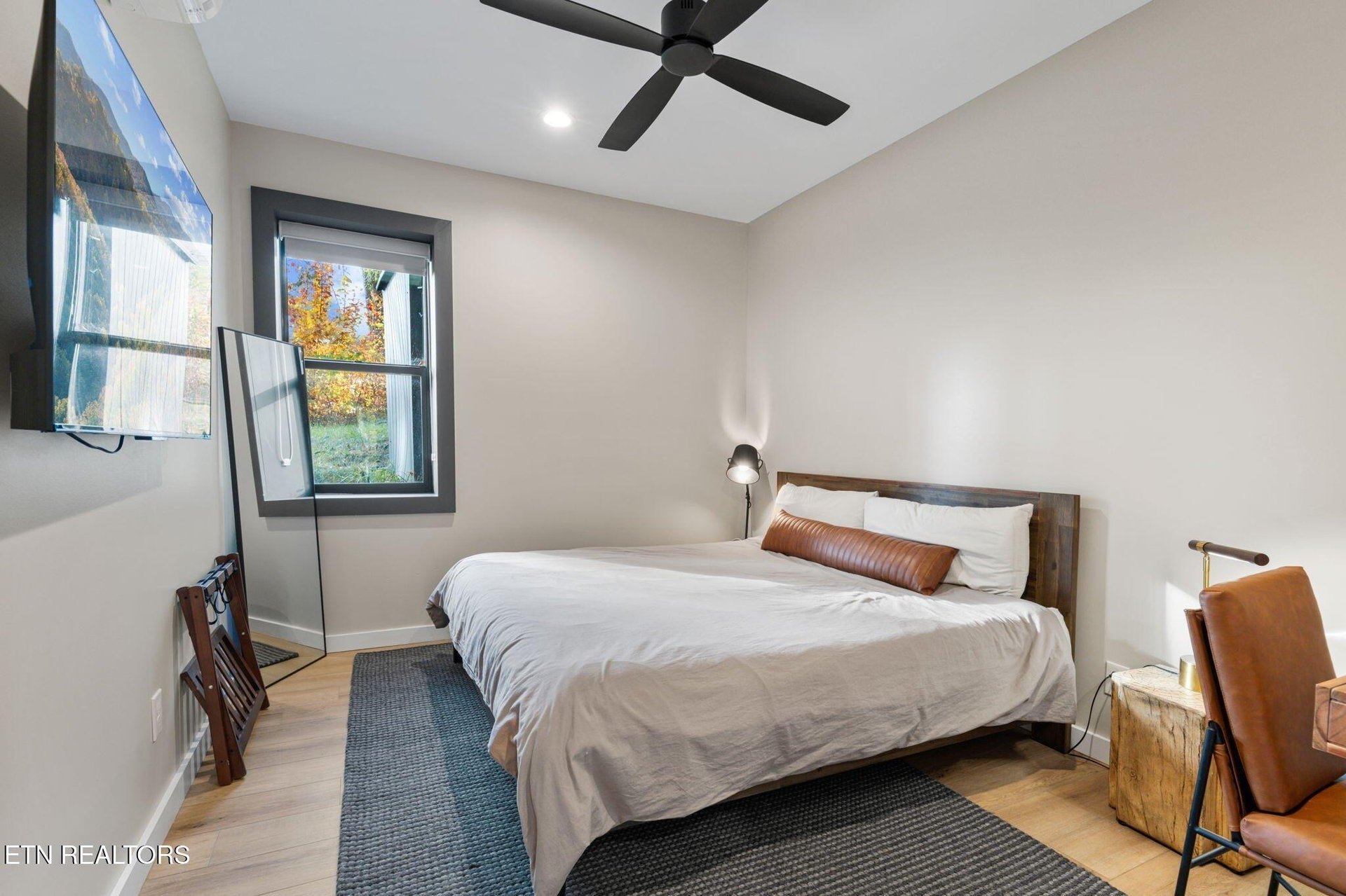 Unwind in your serene bedroom where crisp linens and a modern ceiling fan create the perfect retreat after exploring the area.