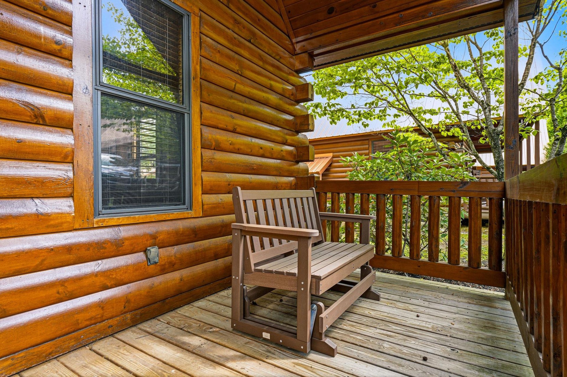 Unwind on your private wooden deck where morning coffee tastes better surrounded by lush greenery and peaceful cabin charm.
