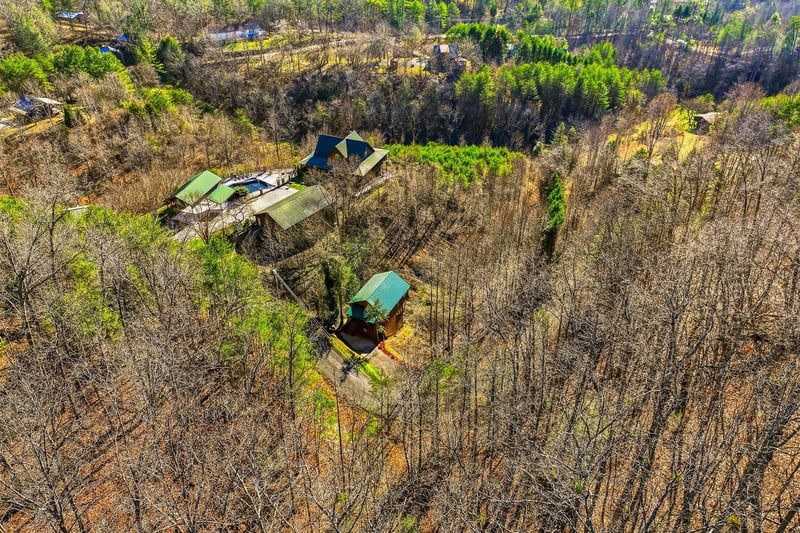 Aerial view showcasing the property nestled among vast woodlands and natural forest landscape in a peaceful rural setting.