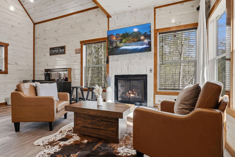 Sink into plush leather chairs by your crackling fireplace, where rustic charm meets modern comfort in this inviting living space.
