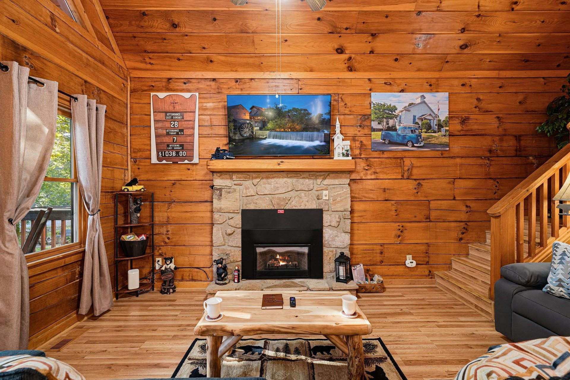 Cozy up in your cabins living room, where warm wood tones and a crackling stone fireplace invite you to unwind after a day of adventure.