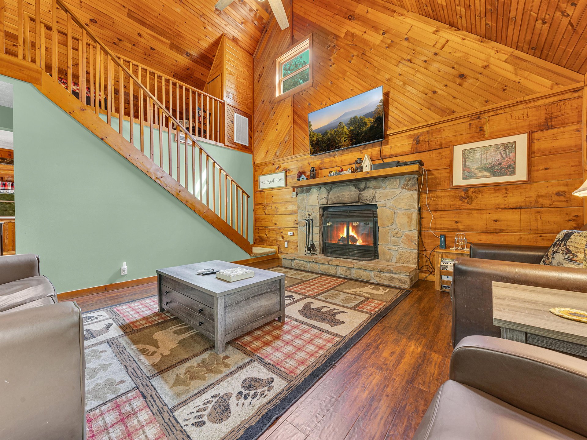 Cozy up by your stone fireplace in this rustic living room, where warm wood beams and comfortable seating create the perfect mountain retreat atmosphere.