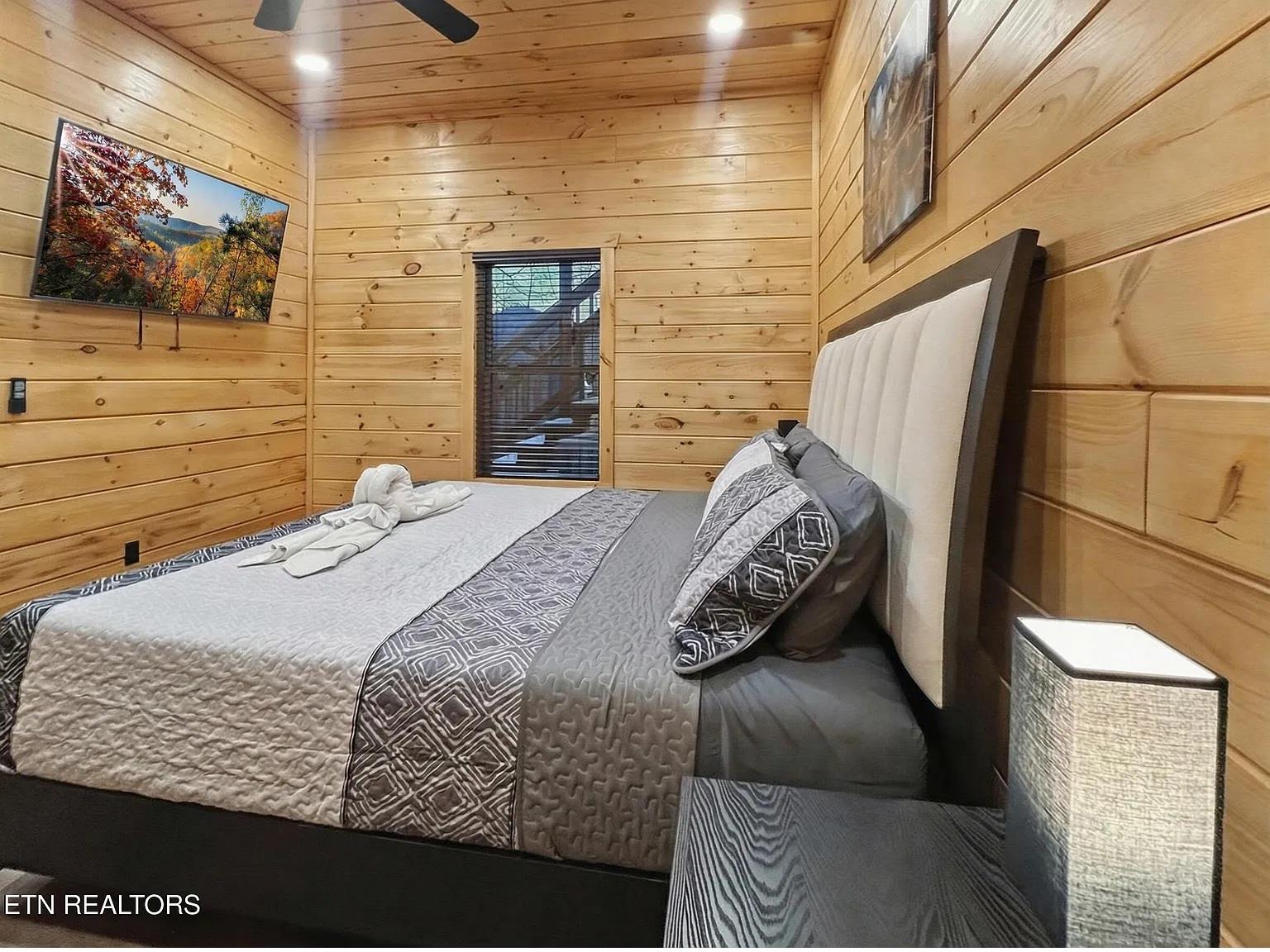 Sink into your cozy cabin bedrooms plush bedding, surrounded by warm wood walls and nature artwork that creates your perfect mountain retreat.
