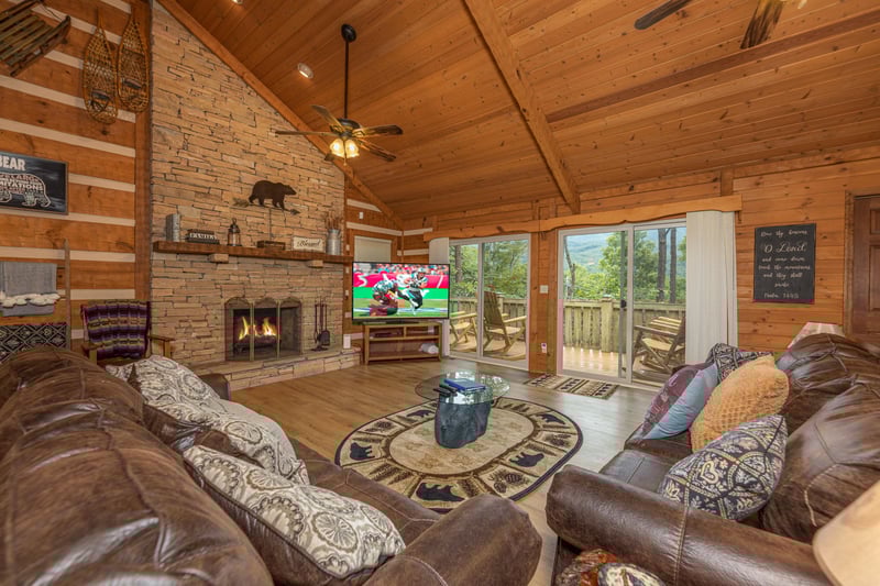 Living room with fireplace, TV, and deck access at Cubs Crib, a 3 bedroom cabin rental located in Gatlinburg