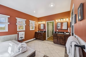 Step into your private spalike retreat with warm terracotta walls, dual vanities, and a soaking tub. Fresh towels and natural light create your perfect escape.