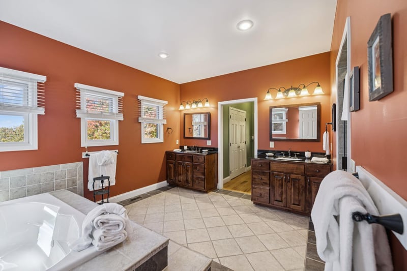 Step into your private spalike retreat with warm terracotta walls, dual vanities, and a soaking tub. Fresh towels and natural light create your perfect escape.