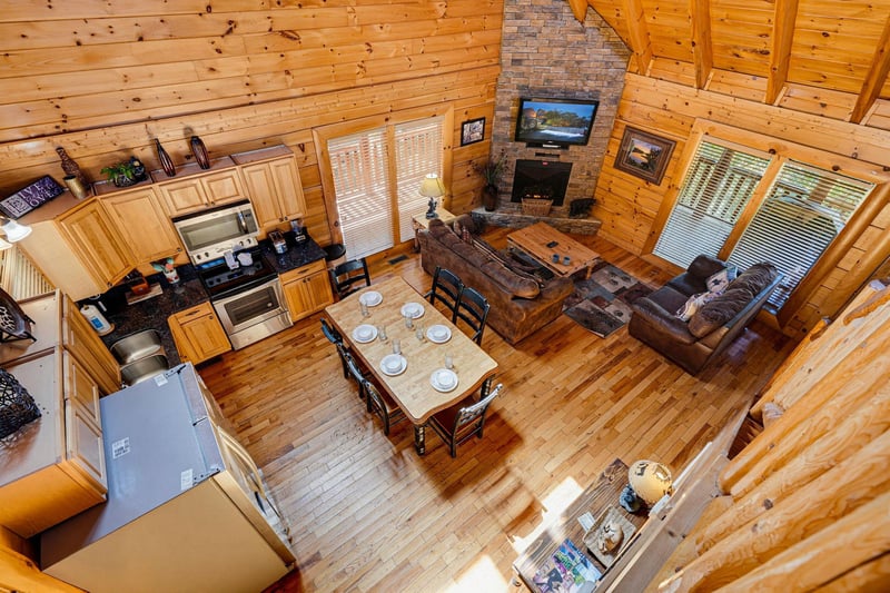 Gather around the rustic dining table and unwind in your cozy living space, where warm wood tones, a stone fireplace, and open views create the perfect mountain retreat.