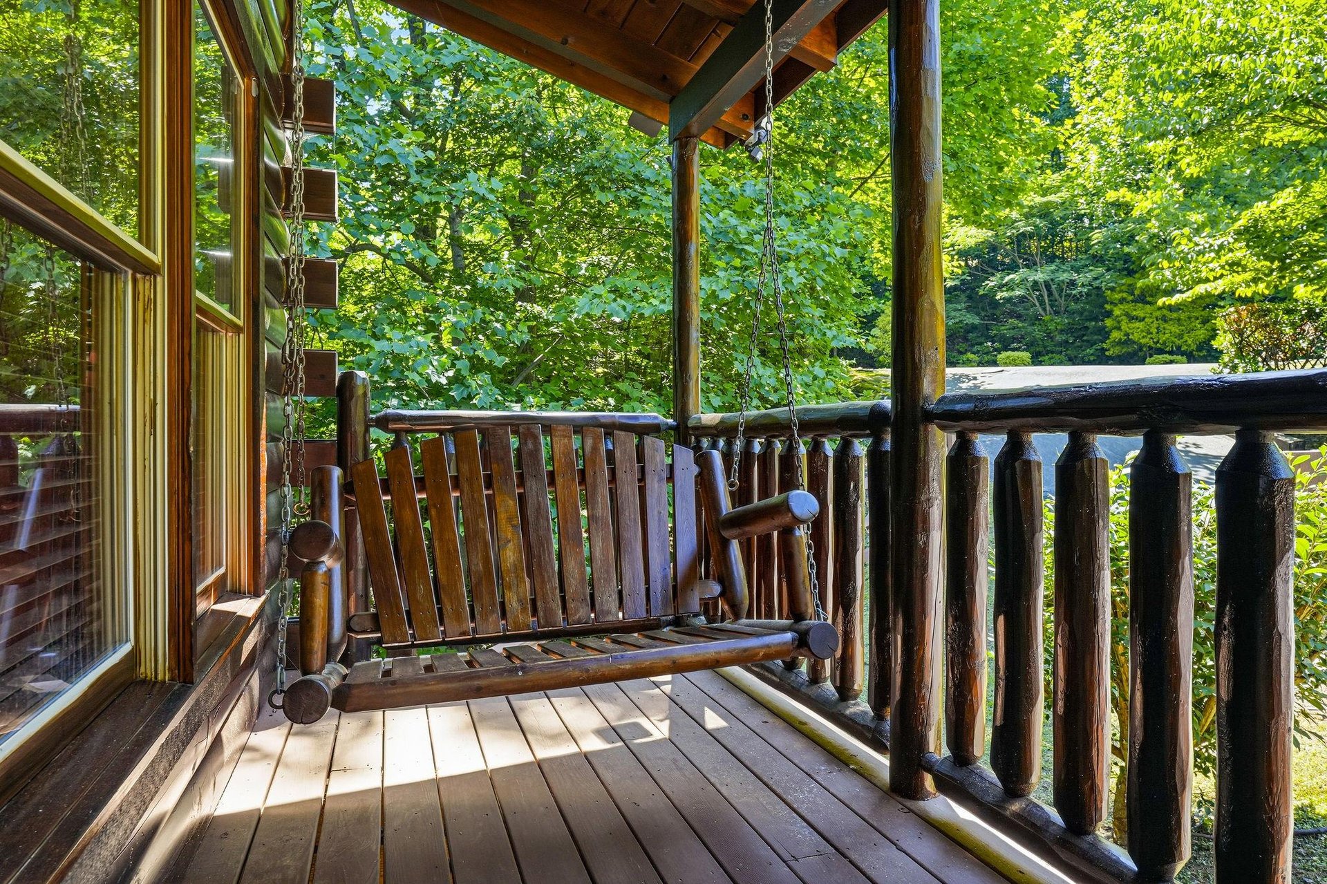 Sway gently on your private wooden porch swing as sunlight filters through towering trees. This peaceful spot invites you to unwind, breathe fresh mountain air, and truly let go.