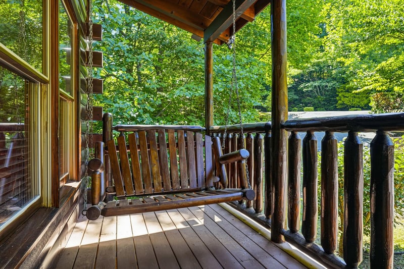 Sway gently on your private wooden porch swing as sunlight filters through towering trees. This peaceful spot invites you to unwind, breathe fresh mountain air, and truly let go.