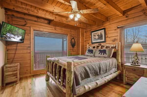 Cozy cabin bedroom with rustic log bed where youll drift off surrounded by warm wood and mountain charm.