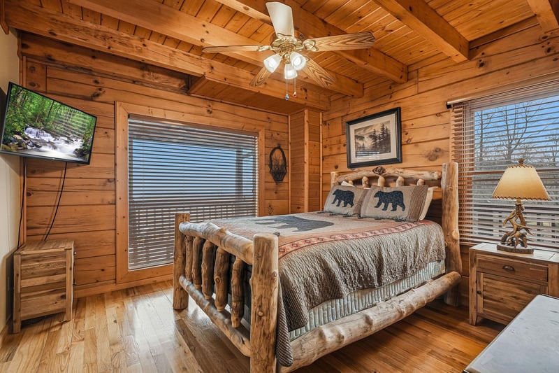 Cozy cabin bedroom with rustic log bed where youll drift off surrounded by warm wood and mountain charm.