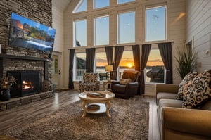 Sink into plush seating as the fireplace warms your evening and a stunning waterfront sunset paints the sky beyond floortoceiling windows, creating an unforgettable retreat.