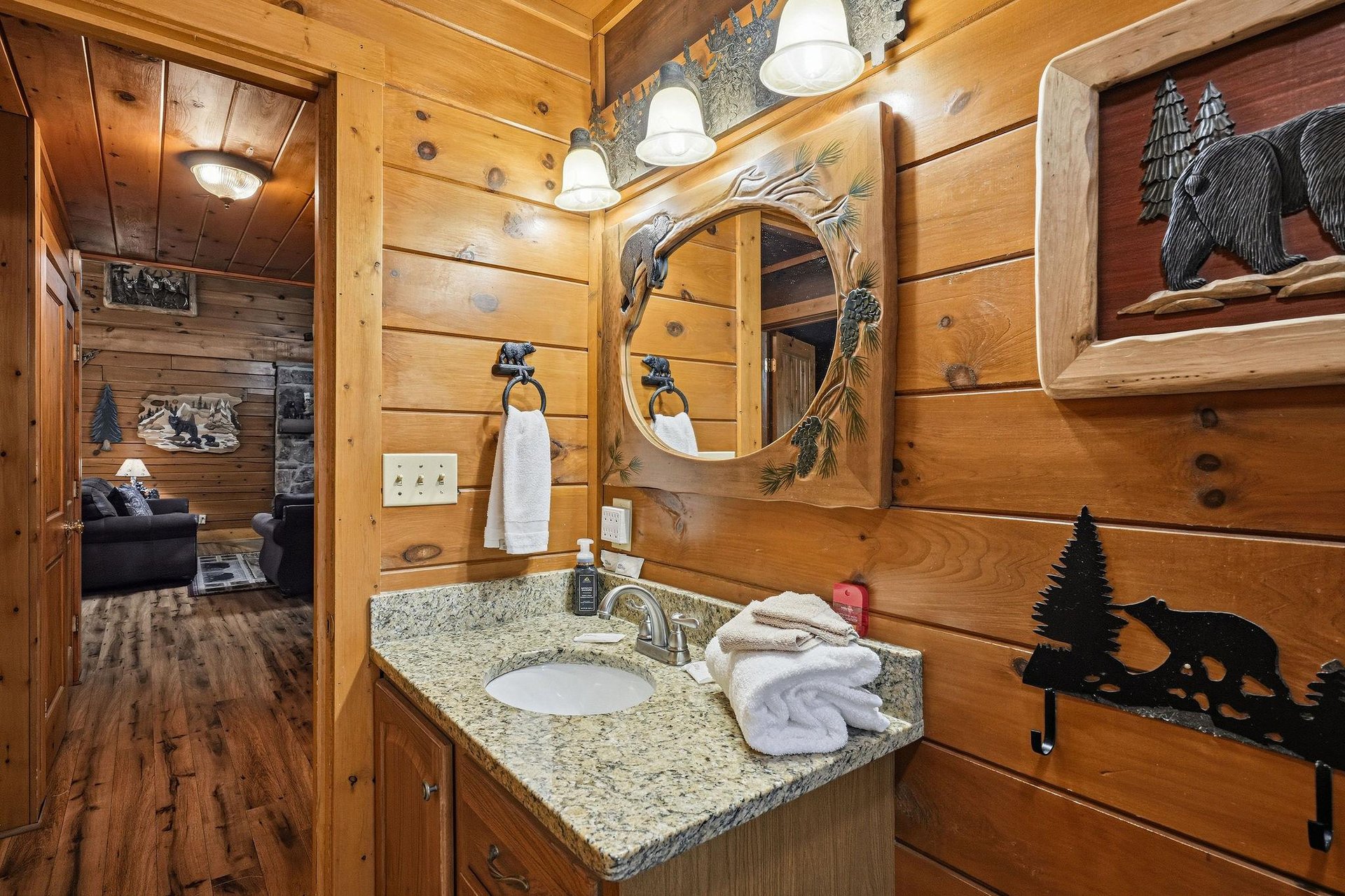 Your private bathroom blends rustic cabin charm with thoughtful touches, featuring warm wood walls, natureinspired decor, and plush towels ready for your mountain getaway.