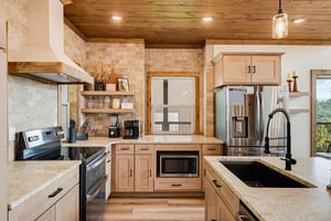 A beautifully designed kitchen awaits, blending rustic warmth with modern convenience. Gleaming appliances, natural wood finishes, and thoughtful details make your vacation cooking feel effortless and
