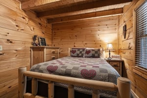 Drift off to sleep surrounded by warm pine walls and rustic log furniture. The vaulted ceiling and cozy heartpatterned bedding create your perfect mountain retreat.
