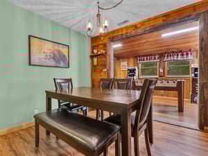 Gather around this warm dining space where rustic wood beams and cozy lighting create the perfect setting for memorable meals together.