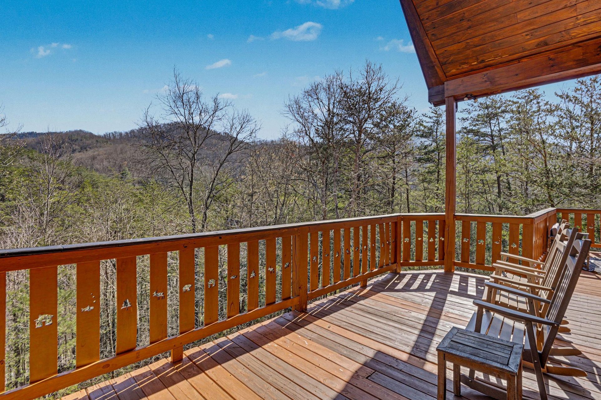 Relax on your private deck with breathtaking mountain vistas stretching endlessly before you. Wooden chairs await your morning coffee ritual.