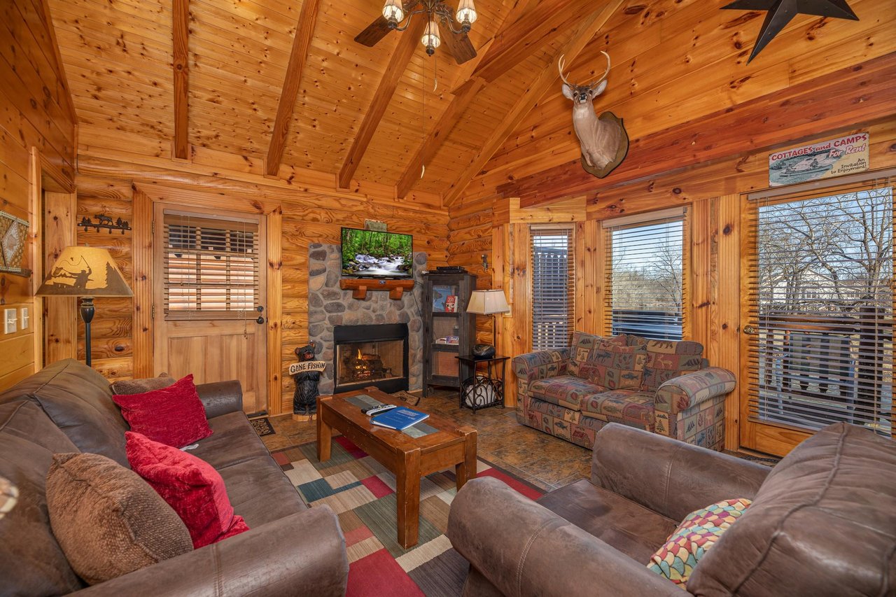 Living room with fireplace, TV, and furniture at Gone Fishin, a 2bedroom cabin rental located in Pigeon Forge