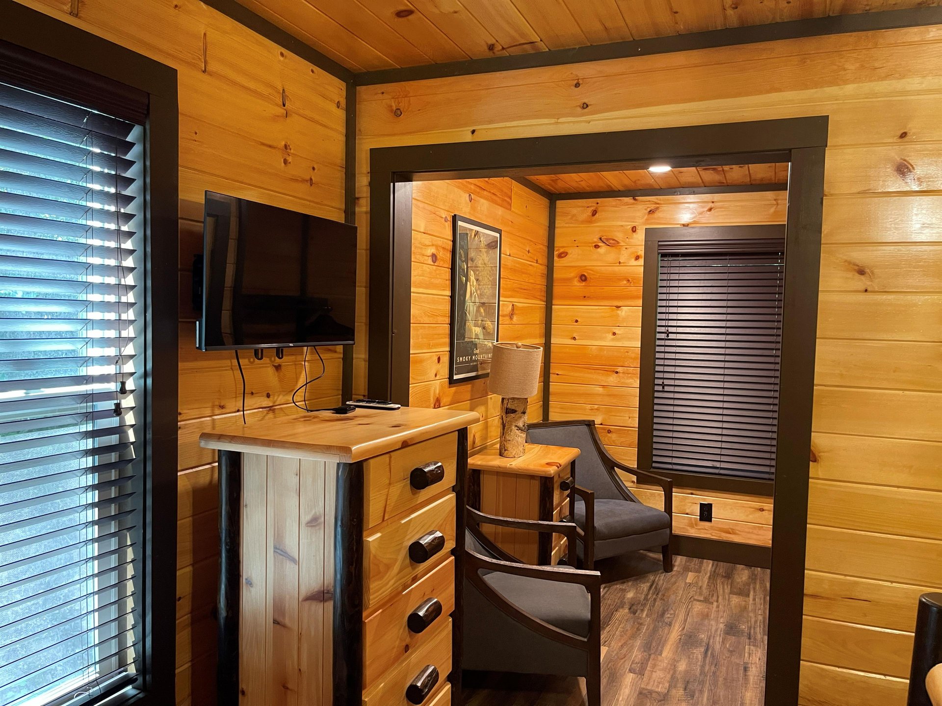 Warm woodpaneled walls surround you in this cozy sitting nook, complete with a comfy chair and entertainment setup—perfect for unwinding after a mountain day.