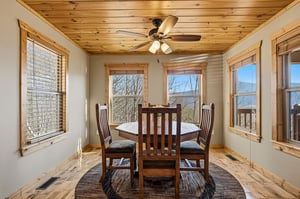 Gather around your rustic dining table where warm wood tones and panoramic windows frame breathtaking mountain vistas for unforgettable meals.
